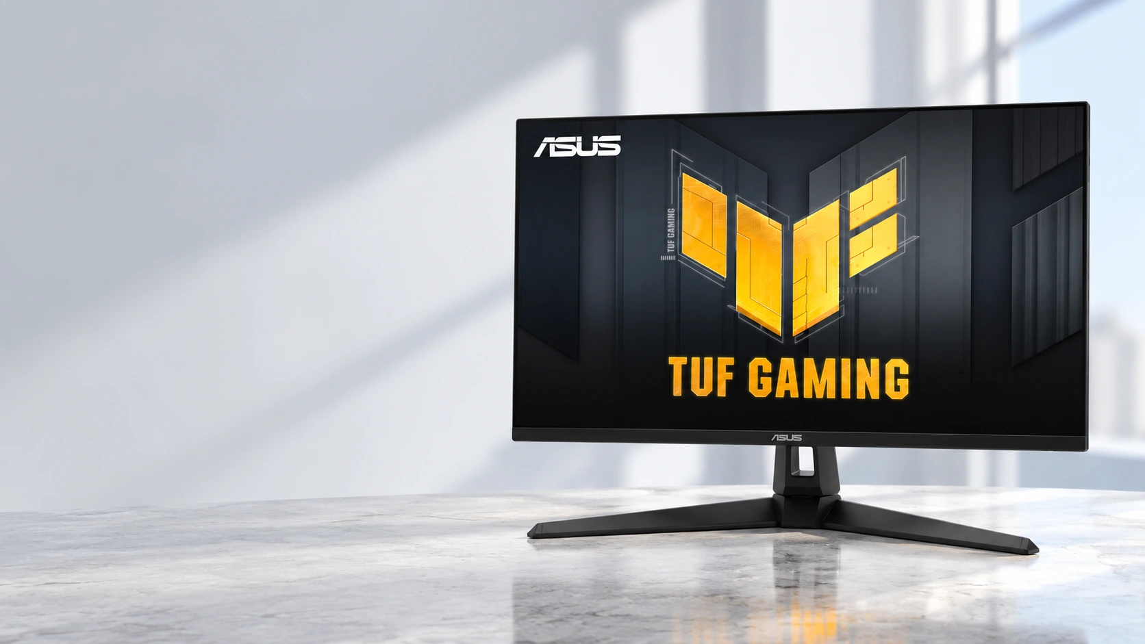 Monitor ASUS TUF Gaming VG27AQ3A sobre una mesa clara con iluminación natural.